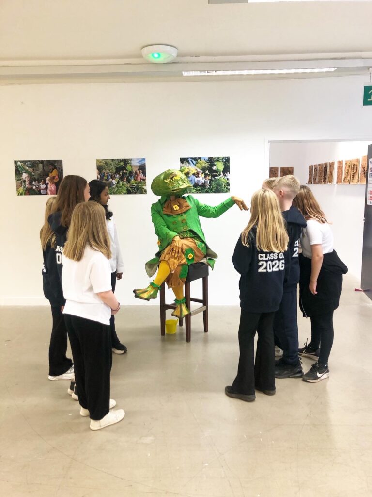 Frog - theatre character in mask is visiting exhibition in Edinburgh and interaction with children - an exhibition visitors.